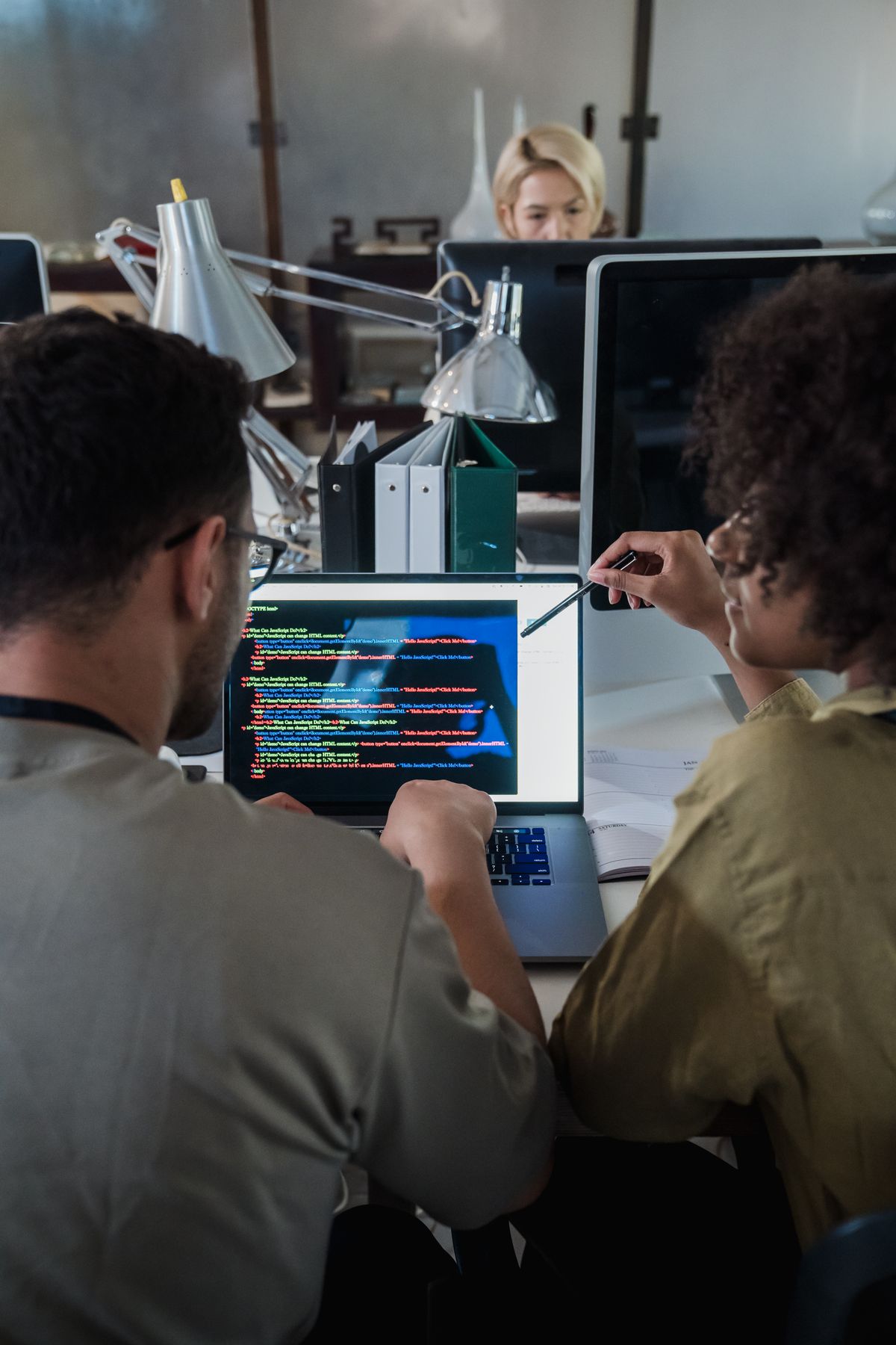 Two colleagues reviewing shared documents on a laptop
