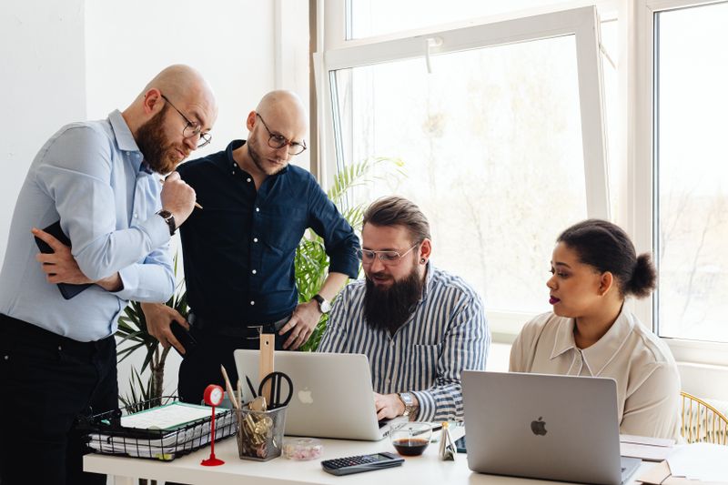 Team discussing a project around a laptop